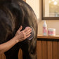 Application du gel de massage Nutragile non gras sur l'épaule d'un cheval.